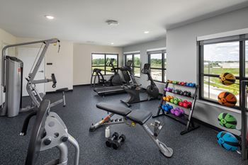 a gym with weights and other exercise equipment and windows